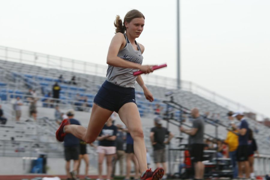 Baton in hand, senior Katie Schwartzkopf runs her leg of the 4x100 meter relay.