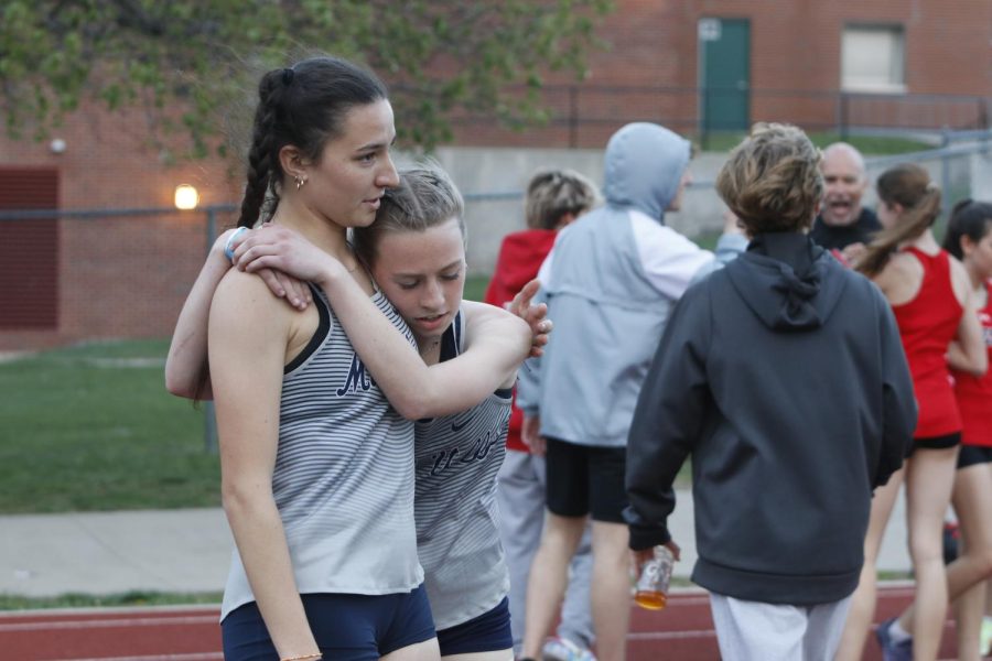 Congratulating each other after the 4x400 meter relay, seniors Quincy Hubert and freshman Josie Benson hug.