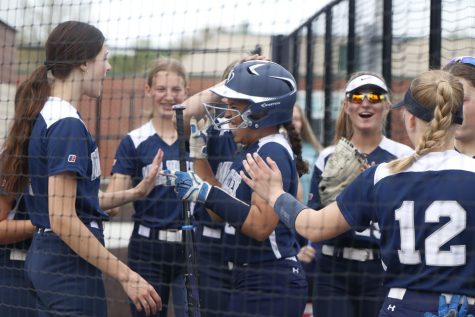 After freshman Kyra Nelson gets an inside the park home run in the first game, her team cheers while she walks in the dugout 