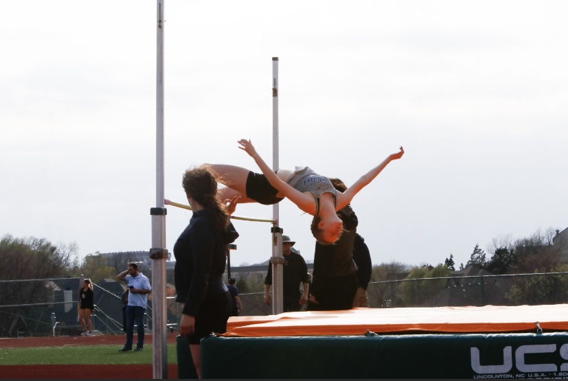 Sophomore Michelle Marney lunges her body over the pole to clear a final height of 410 in high jump. Marney placed sixth.