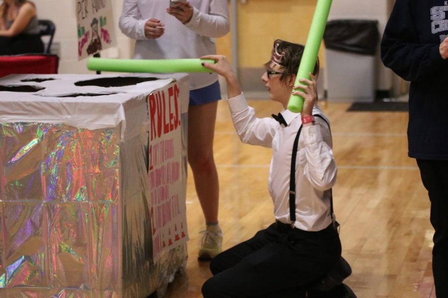 Kneeling on the floor, sophomore Chase Beaver plays human Whack-A-Mole.