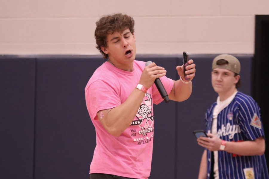 Holding up a microphone, senior Sean Allerheiligen sings for the audience during the open mic portion of Relay for Life.