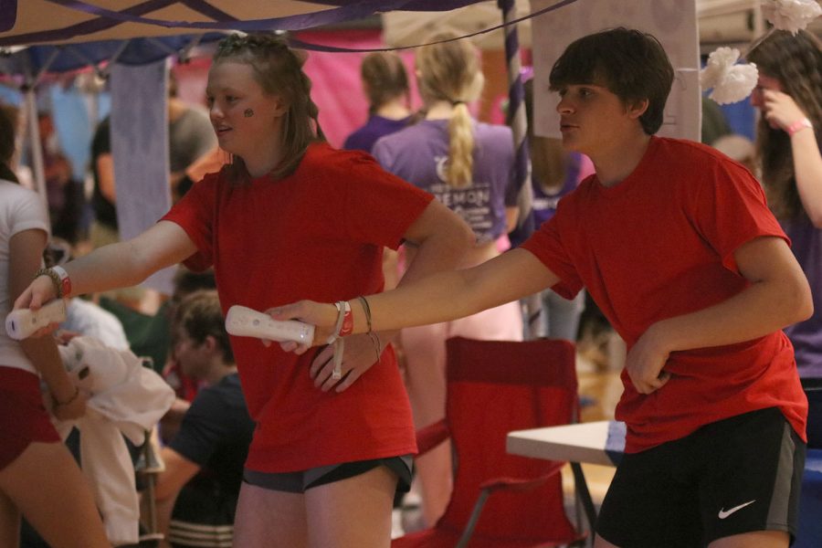 Holding Wii remotes in their hands, sophomores Ella Hansen and Logan Holdren face off against each other in Just Dance.