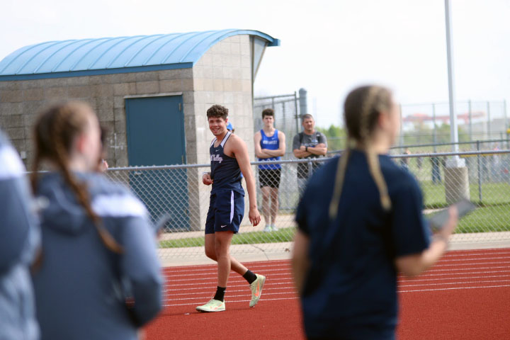 After completing a high jump round, senior Kendrick Jones receives congratulations from the rest of his team.