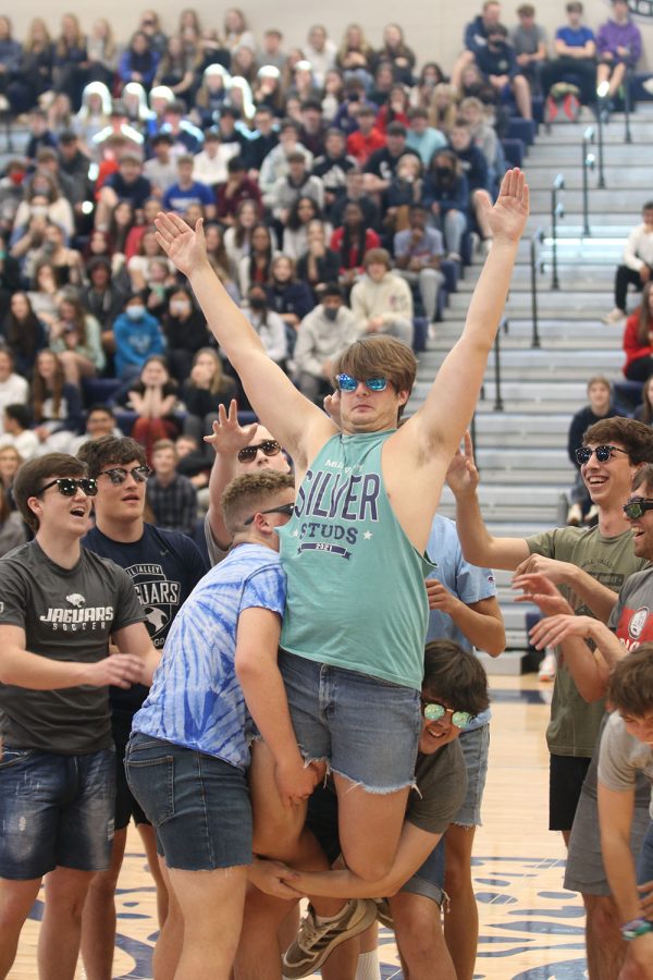 Arms up, senior Evan Harris enjoys being lifted into the air as part of the silver studs performance during the prom pep assembly Friday, April 1. 
