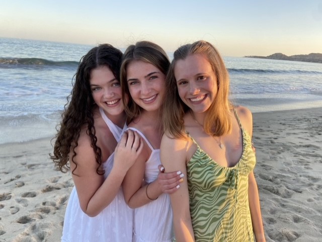 Standing next to each other on the beach, seniors Katie Schwartzkopf, Logan Pfiester and Sydney Wootton pose for a photo during their senior spring break trip. Pfiester, Schwartzkopf, Wootton have a friendship that spans the vast majority of their time in school. Their bond, starting in third grade, has been strengthened through their families becoming close with each other.