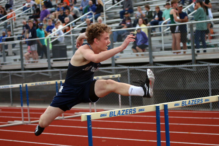 Junior Finn Campbell jumps towards the finish line during hurdles.