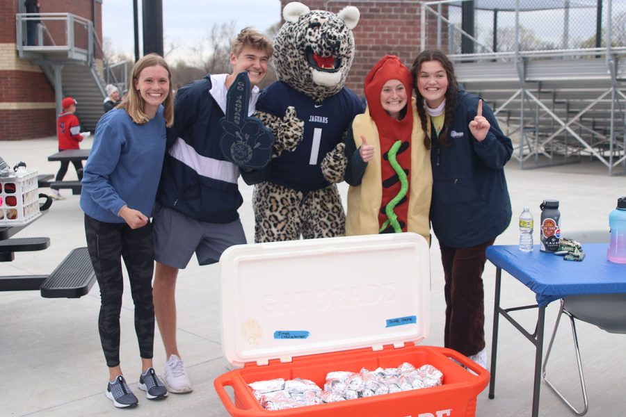 Seniors Katie Schwartzkopf, Bret Weber, Lauren Walker and Sydney Wootton pose with JJ the Jaguar while selling hotdogs during Tailgate Tuesday. 