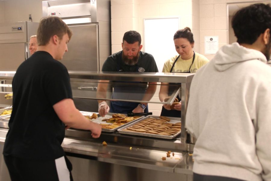 Moving down the line, senior Jackson Davis is served french toast and pancakes by athletic director Brent Bechard and art teacher Erica Matyak. 