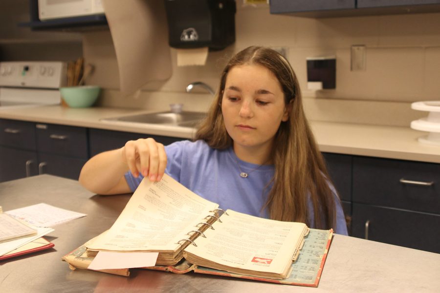 Flipping a page, freshman Molly Griffin looks through a family recipe book that has been passed down through generations.