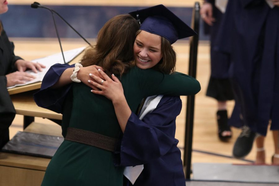 After receiving her diploma, senior Shelby Easum embraces her former administrator with a hug.