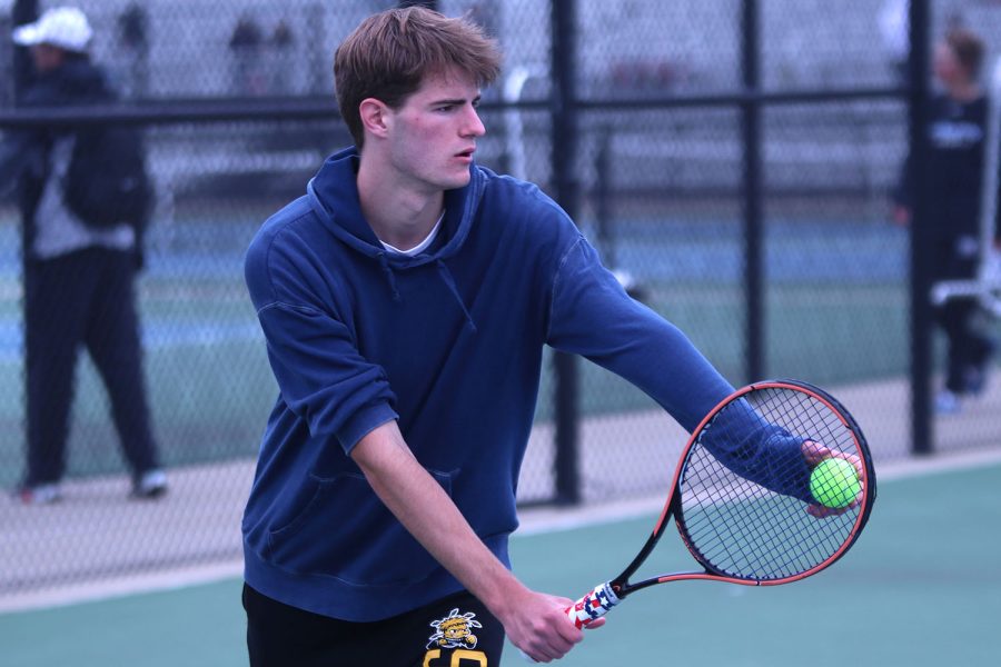 Thinking of his next move, senior Xander Pickett prepares to serve the ball.