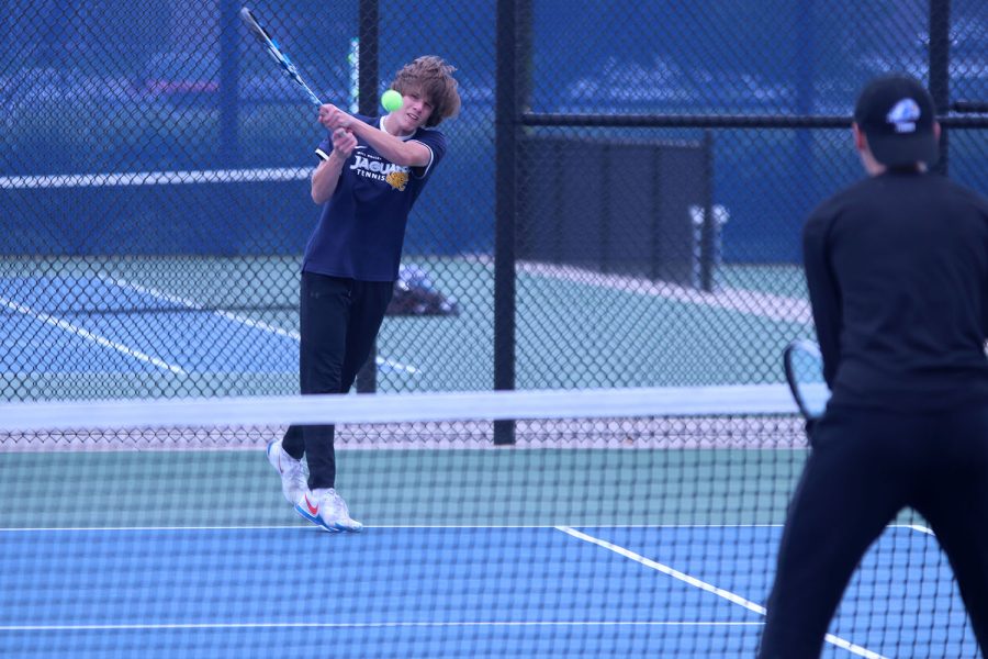 managing to reach the ball, senior Derek Mulder, returns it to the other side.