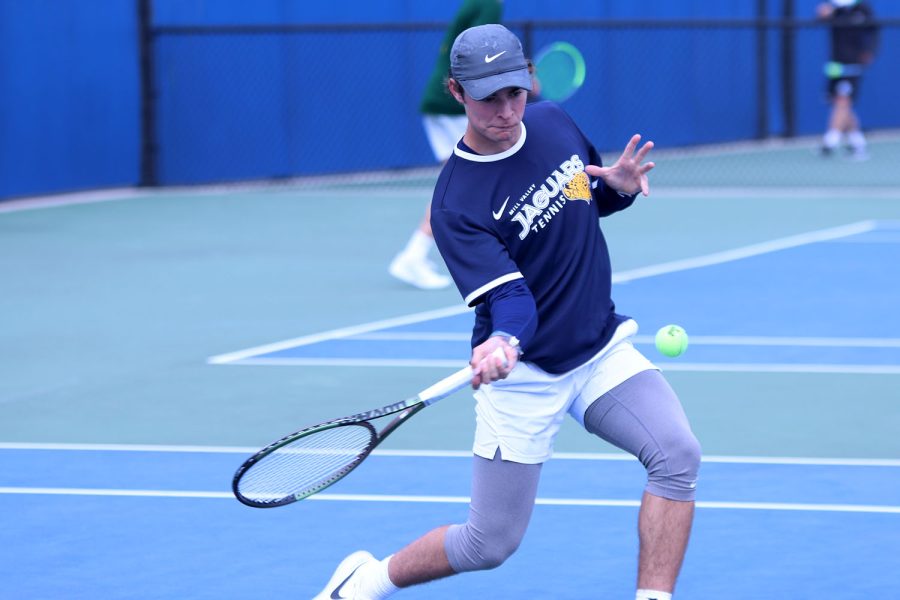 Managing to get under the ball, senior Gage Foltz gets ready to hit it back to his opponents side.