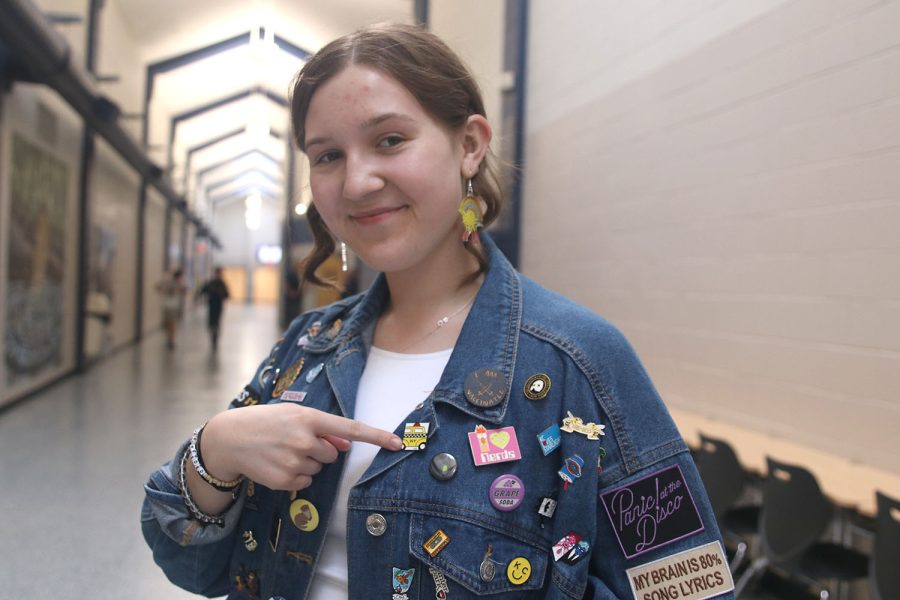 Wearing her jean jacket, junior Asa Esparza points to a pin out of her collection.