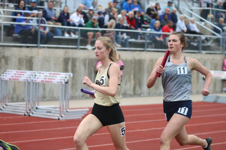 Attempting to pass Blue Valley Southwests Anna Strickland, senior Logan Pfiester increases her stride toward the end of her leg of the 4x800 meter relay.