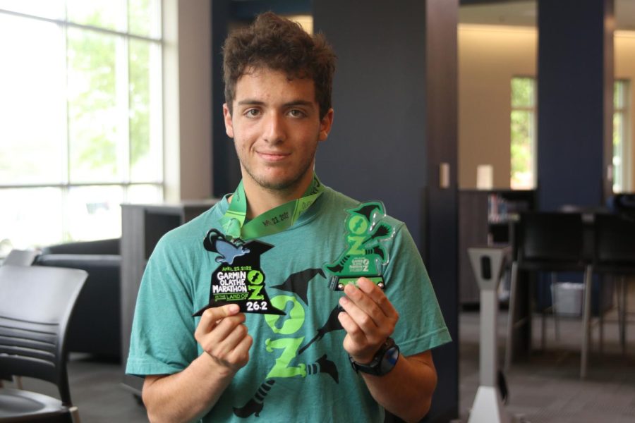 Setting a new school record, senior Vinny Bruno holds his medals proudly after finishing in first place in the Garmin Olathe Marathon, Tuesday, May 10. 