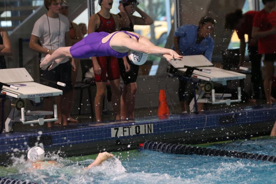 Diving off the block, sophomore Ella Hansen jumps into the relay following junior Eva Garcia Cuenca Friday, May 6 at the Shawnee Mission Aquatic Center.