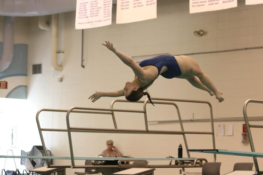 Participating in a competition against Blue Valley Northwest, junior Cassie Frias completes a back dive half in the free position on Thursday April 28.