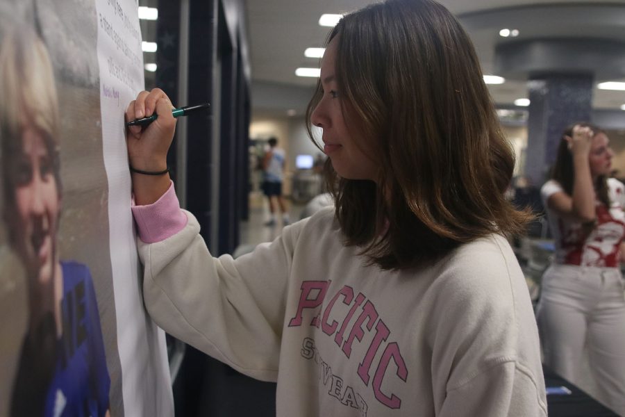 Marker in hand, senior Katelyn Krosky signs the board to pledge against drugs. 