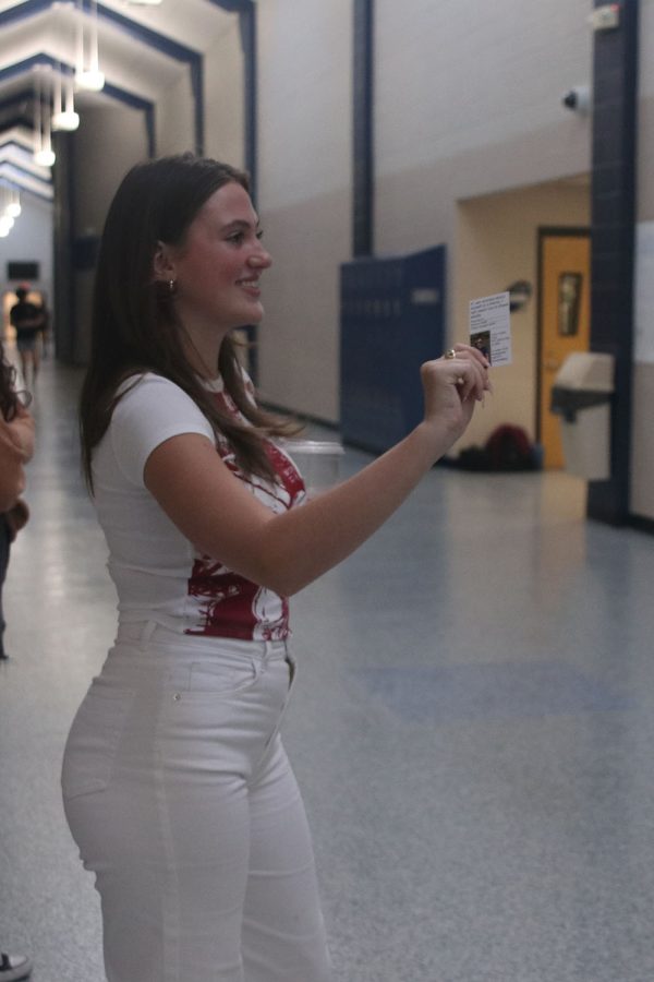 In the main hall, Jag Pride member senior Isabelle Skramstad passes out informational cards to students. 

