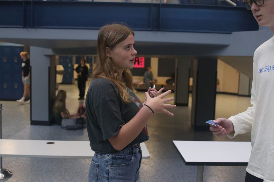 By the main staircase, Jag Pride member senior Helen Springer explains the importance of pledging to a drug free life to a student.
