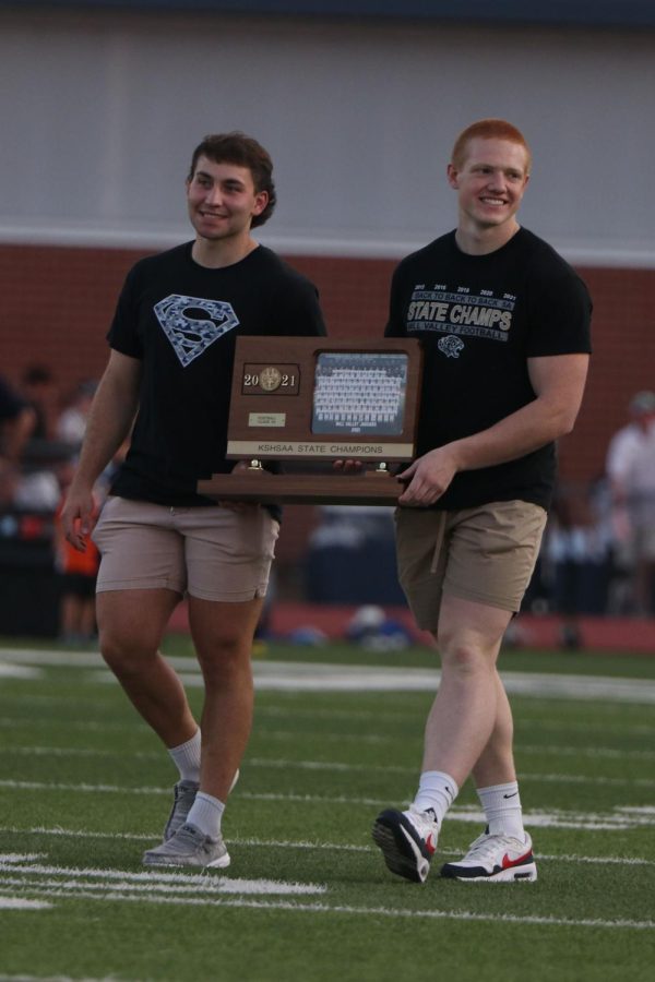 Being recognized for their state championship win, alumni Jared Napoli and Reice Kennedy walk across the field. 