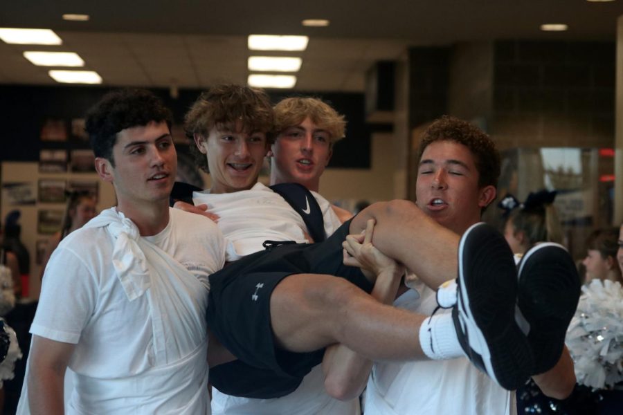 Walking into the building, seniors Hayden Jay, Luke Shideler and Zack Kellogg carry a freshman boy to the gym.