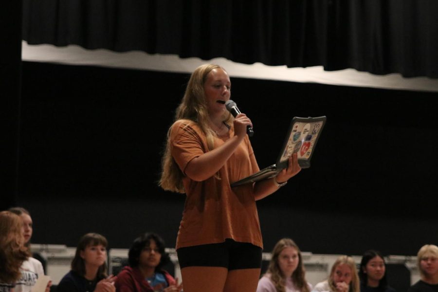 Standing center stage, student body vice president senior Avery Blubaugh introduces the vice presidential candidate speeches.