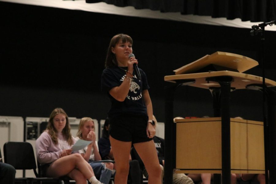 Standing away from the podium, freshman Maddie Martin delivers her candidate speech.