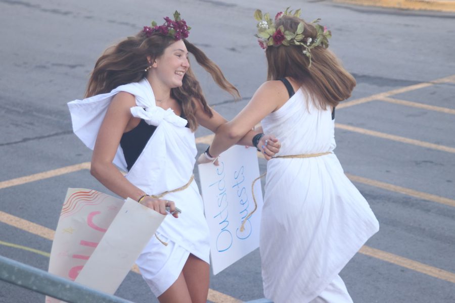 While waiting to greet incoming freshmen, juniors Kynley Verdict and Lucy Roy dance outside the activity entrance. 