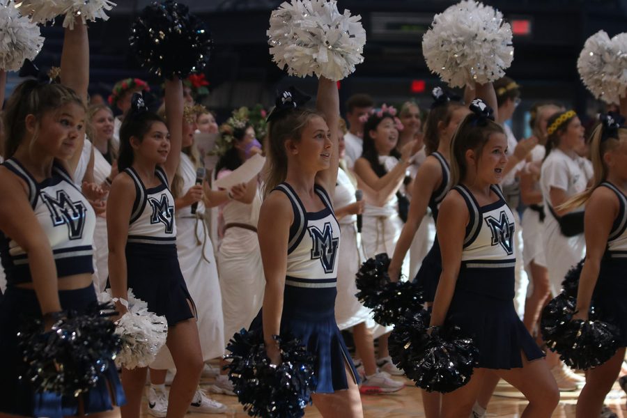 With their pom poms in the air, the cheerleaders help lead the school fight song. 