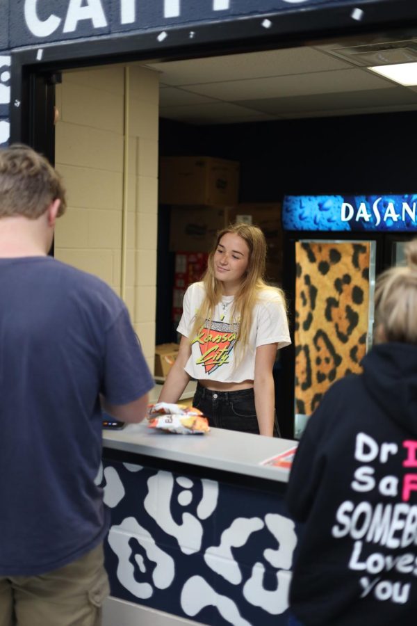 Checking out a customer, senior Libby Strathman recives his payment, Monday September 19. 