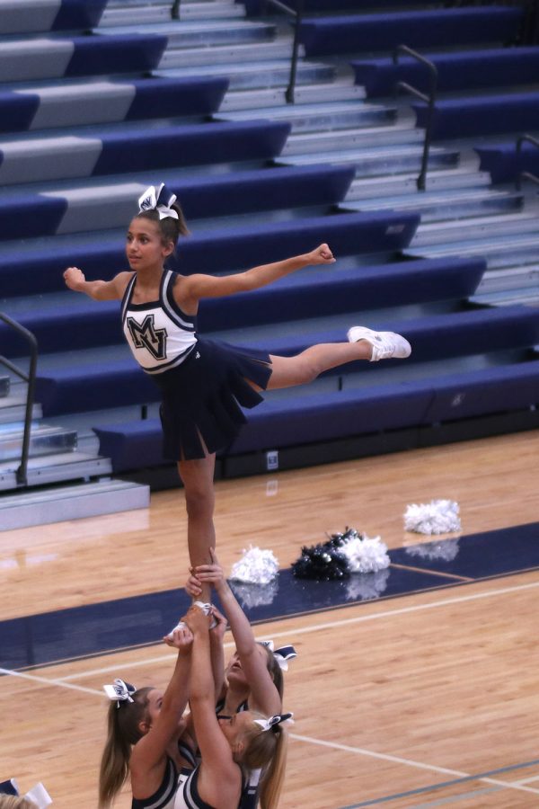 Focused, sophomore Jada Winfrey extends her leg in the air while practicing for her performance in the pep assembly.