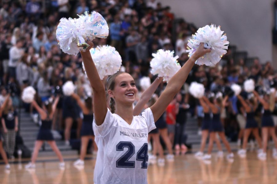 Poms raised in the air, junior Alli Gervais smiles at the student section while performing the fight song.