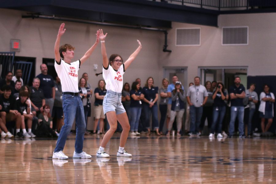 Arms raised, senior Homecoming candidates Sonny Pentola and Ava Gourd dance while wearing Vote for Pedro shirts from “Napoleon Dynamite.”