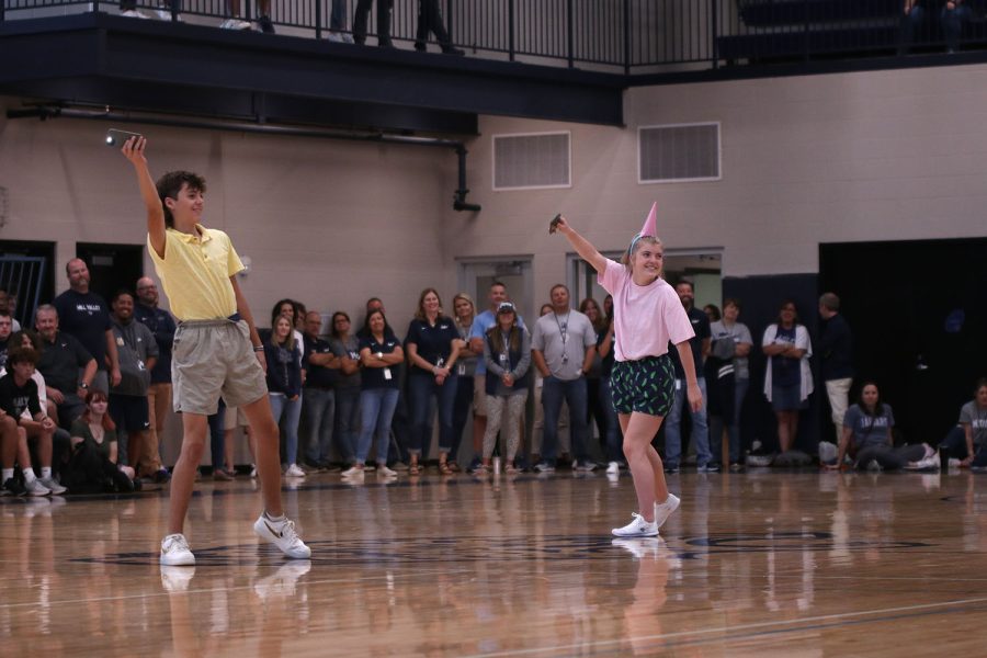 Dressed as Spongebob and Patrick, senior homecoming candidates Eli Olson and Jenna Myres wave flashlights in the air.