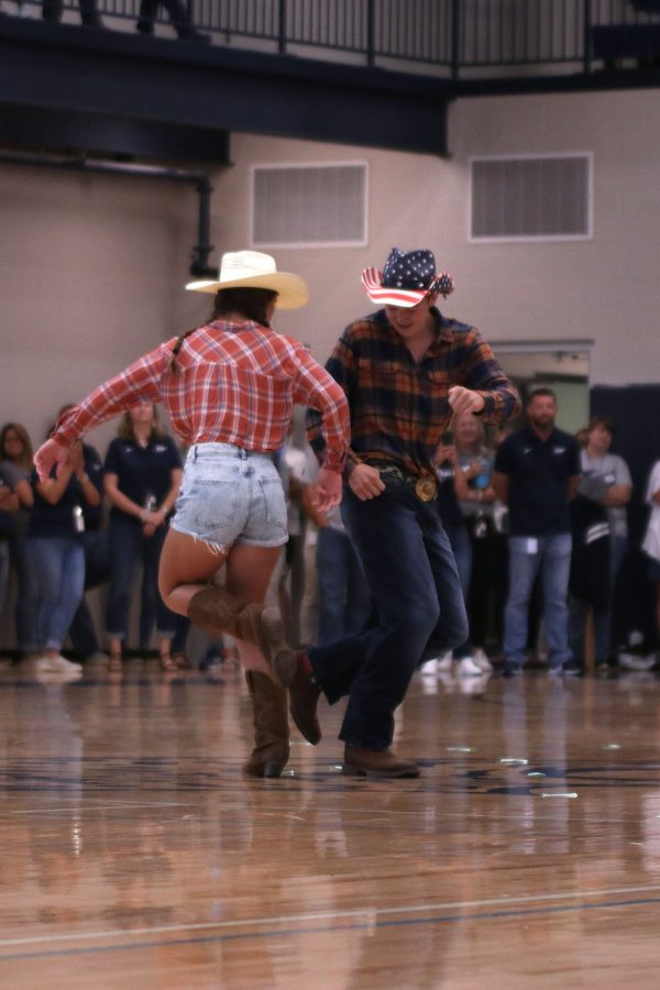 While tapping boots, senior homecoming candidates Laney Reishus and Brody Shulda dance to Cotton Eyed Joe.