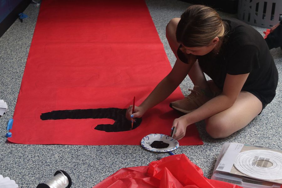 Focused on painting, junior Kate Pfeister paints the letter “J” in junior.  