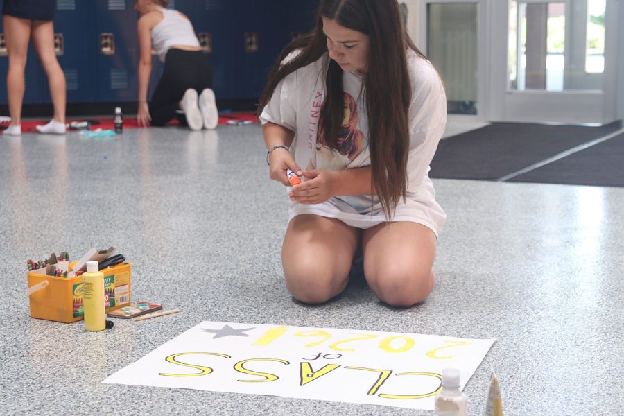 Closing the cap of the glue, freshman Lily Suman finishes decorating her poster. 
