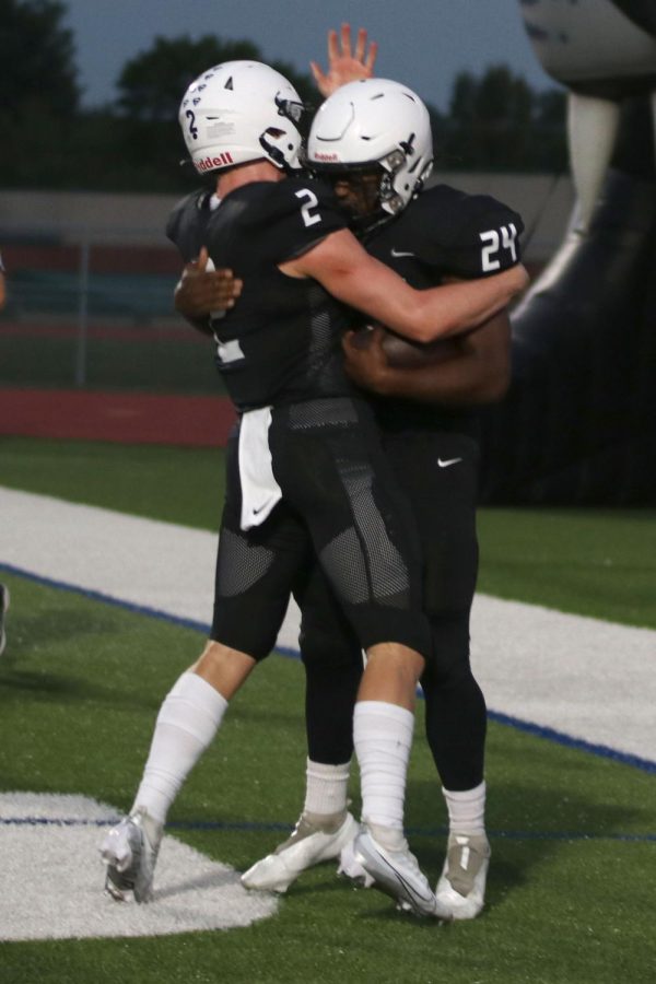 Filled with excitement, senior Hayden Jay pats senior Amarian Graves on the helmet after he scores a touchdown.