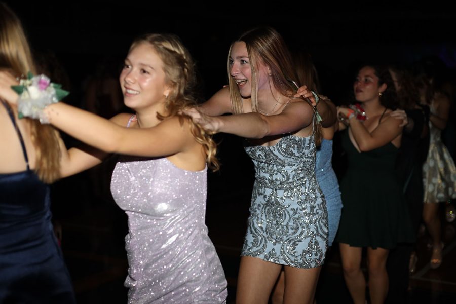 In the conga line, junior Sydney McGlasson smiles as she holds onto the person in front of her.