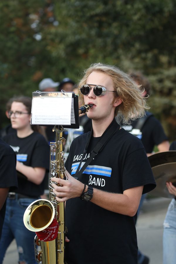 Playing his saxophone, junior Evan Mack marches along with the band down the parade route.