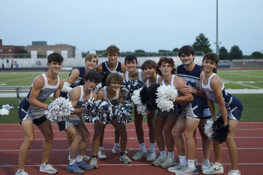 Gathered on the track, junior and senior powderpuff cheerleaders pose for a photo before the game. 