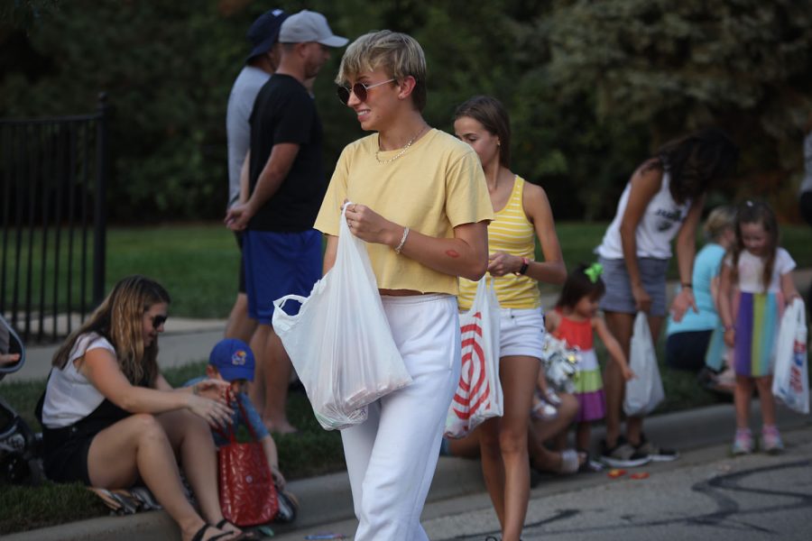 Reaching into his bag, freshman Gus Goetsch passes out candy with other members of the freshman float. 