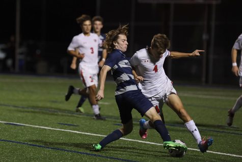 With his foot out, senior Toby Kornis fights for control of the ball. 