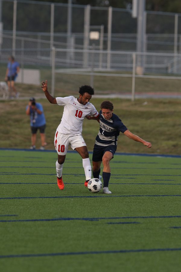 Pushing against an opposing defender, senior Luke Shideler tries to take control of the ball. 