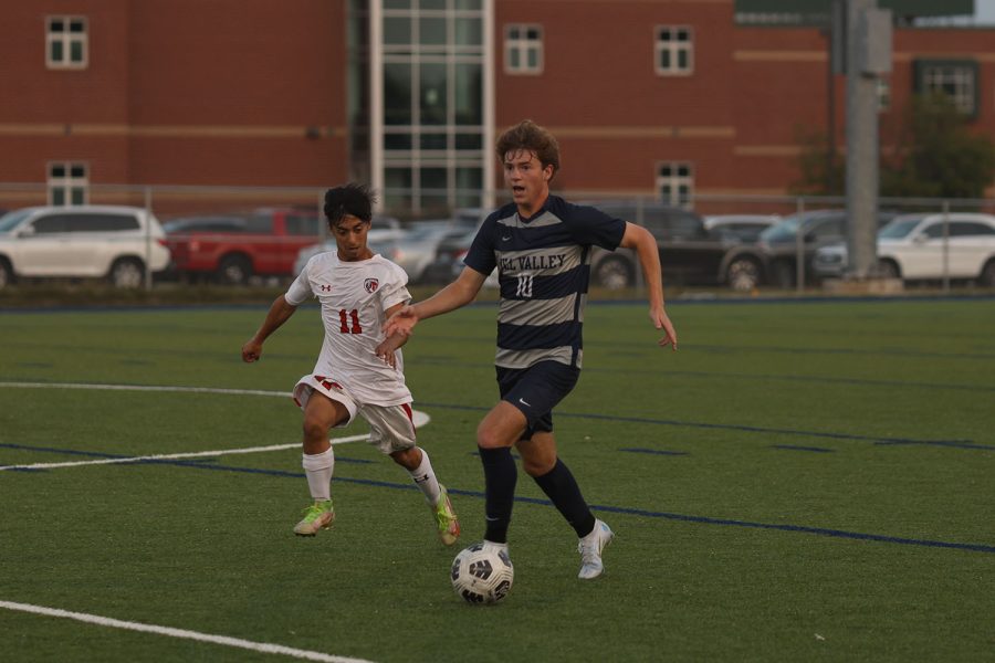 With a defender behind him, senior Nico Pendleton takes the ball down the field. 