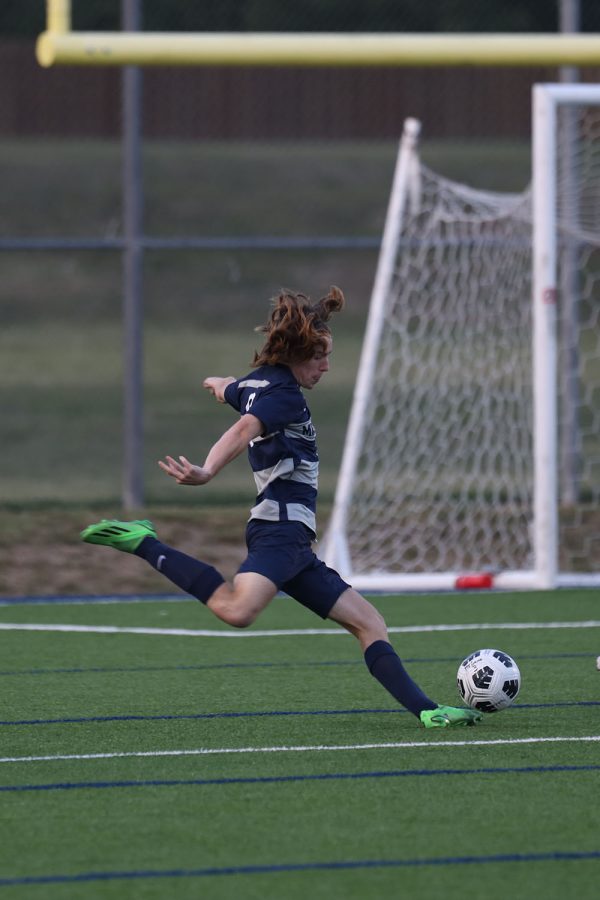 Near the opposing teams goal, senior Toby Kornis prepares to kick the ball.