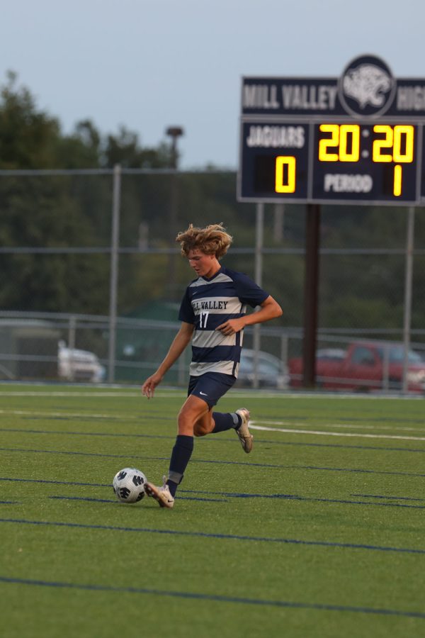 Running down the field, senior Nick Hodson prepares to pass the ball. 
